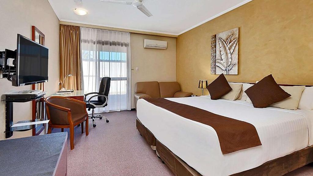 怀阿拉Comfort Inn Whyalla的酒店客房设有一张大床和一张书桌。