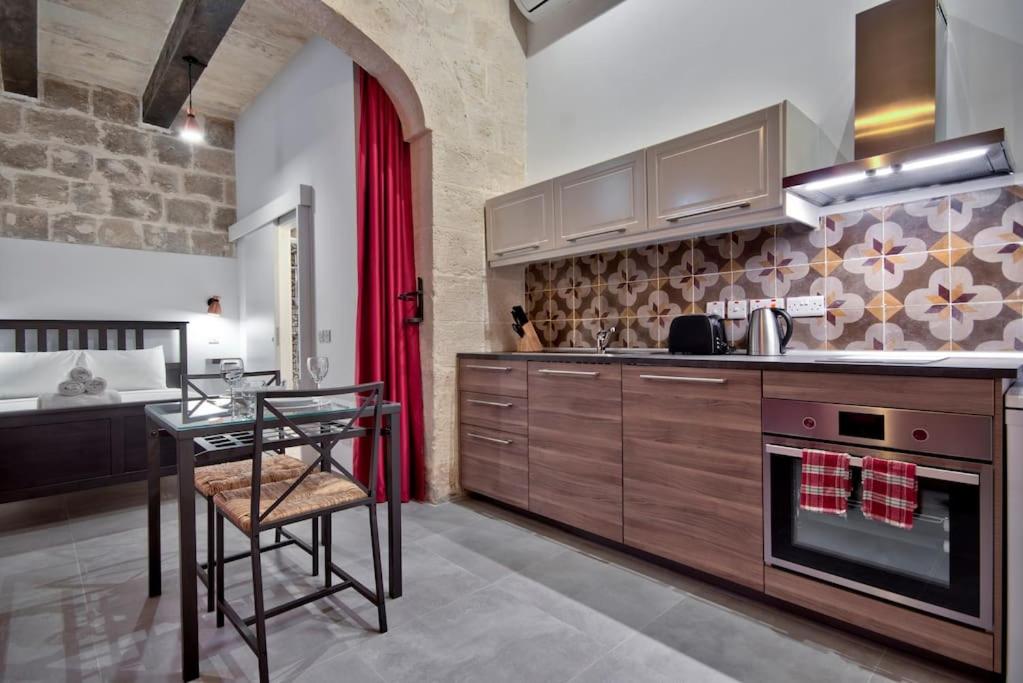 瓦莱塔Vallettastay Old Lodge Studio 5的一间带桌子的厨房和一间餐厅