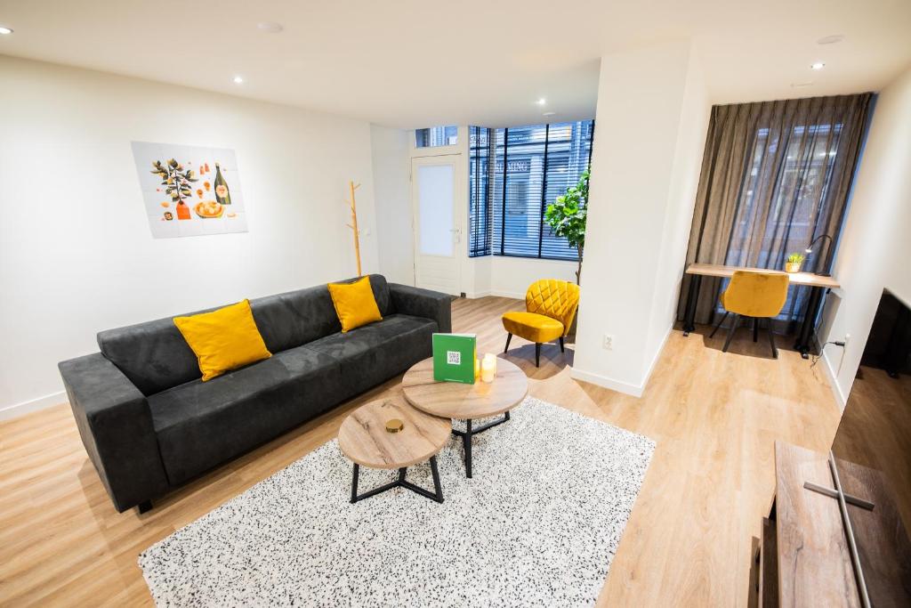 蒂尔Great 95m² Two-Bedroom Apartment的客厅配有黑色沙发和黄色枕头