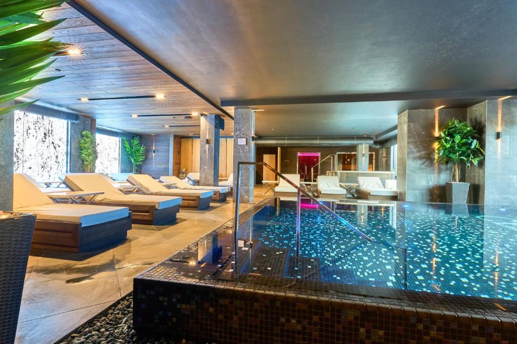 布克维Twins Hotel & Spa的带沙发的客厅中的游泳池