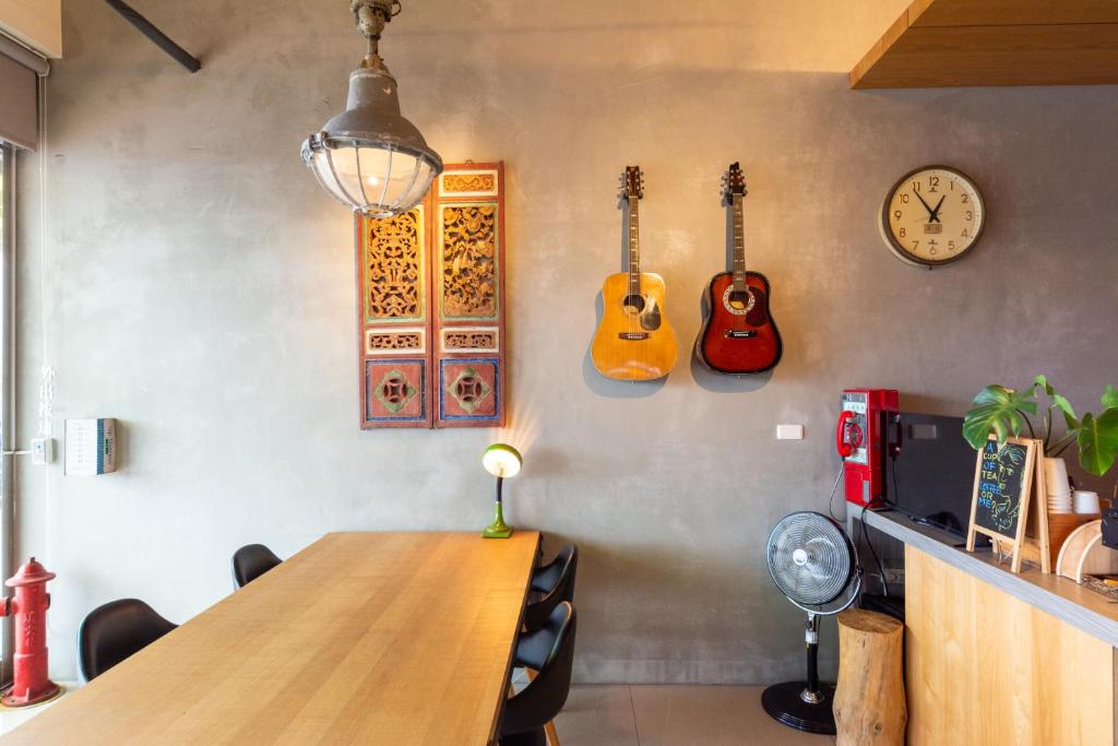 恒春古城時光輕旅 Time INN的墙上有一张桌子和三把吉他的房间