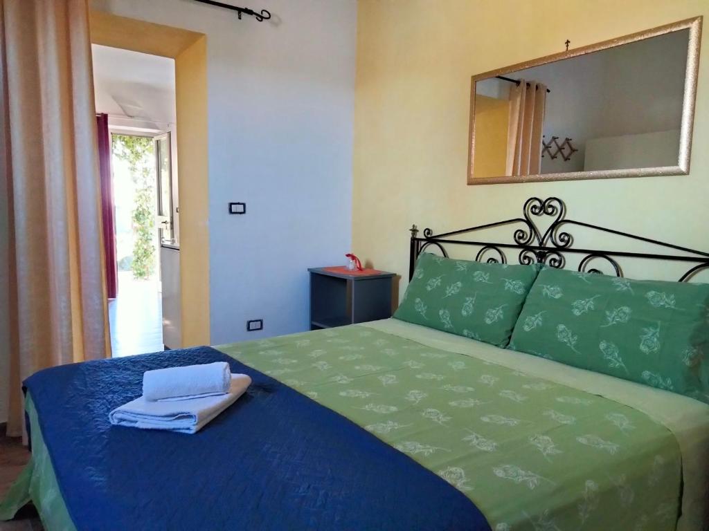 拉卡莱Salento nel cuore的一间卧室配有一张带蓝色床单和镜子的床