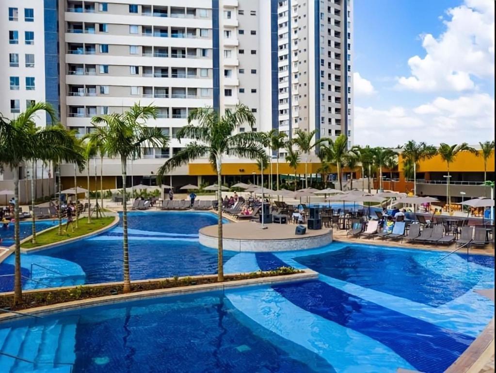 奥林匹亚Apartamento dentro de resort próximo do Thermas dos Laranjais的一座棕榈树和建筑的大型游泳池