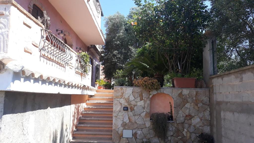 皮诺港Casa vacanza "Maestrale "的楼梯通往一座带石墙的建筑