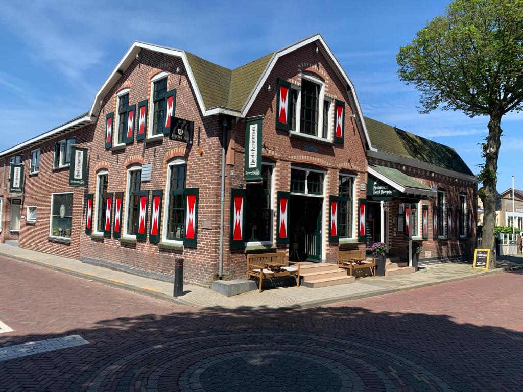 艾格蒙宾能Herberg Binnen的街道上一座带红色百叶窗的大型砖砌建筑