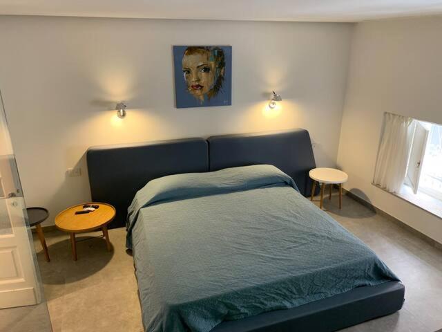 卡塔尼亚SUITE Nobile的卧室配有蓝色的床和墙上的绘画作品