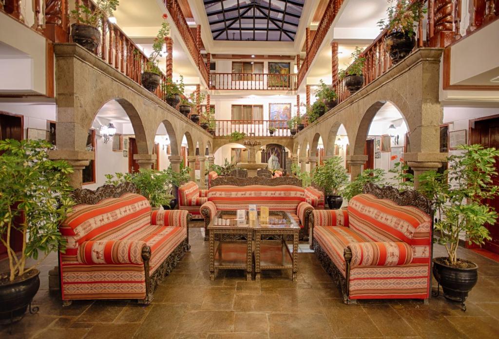 库斯科Munay Wasi Inn的大堂配有沙发、桌子和盆栽植物