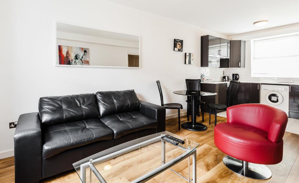 都柏林帕奈尔公寓酒店的客厅配有黑色沙发和红色椅子
