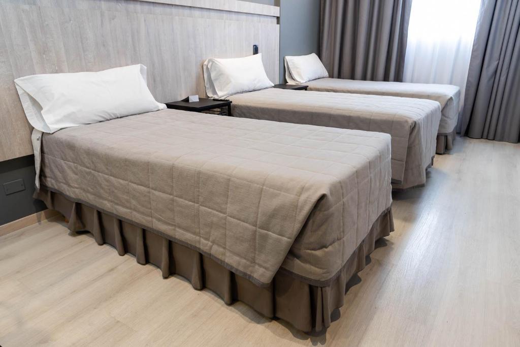 门多萨HOTEL M的一间酒店客房,房间内设有两张床