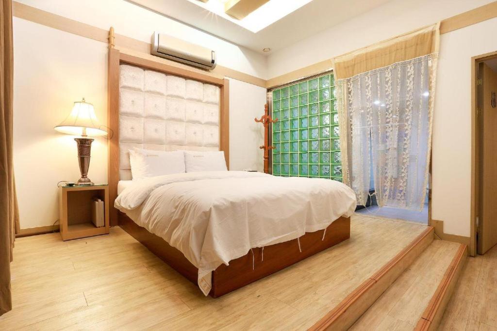 坡州市Carlton Hotel的一间卧室设有一张大床和一个窗户。
