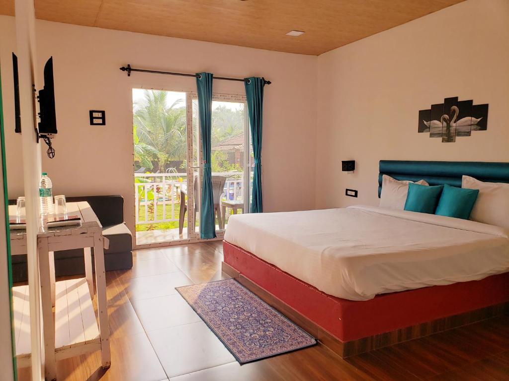 阿姆波尔White Truffle Resort, Arambol的一间卧室配有一张床、一张书桌和一个窗户。