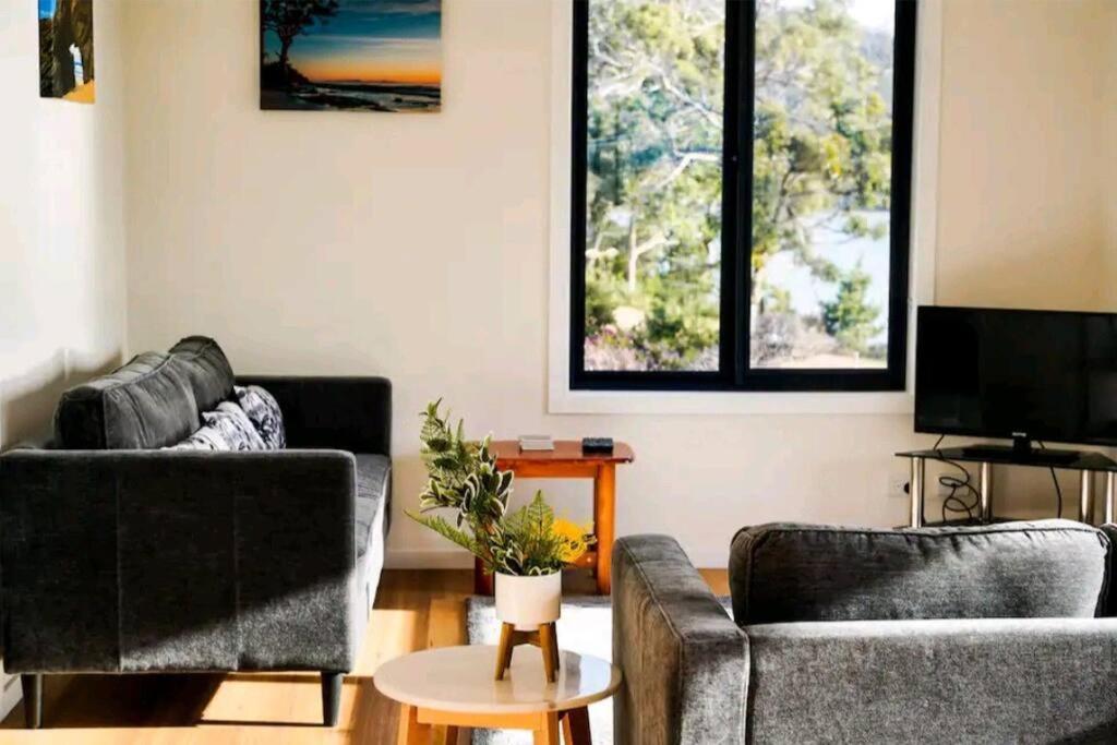 LunawannaRockpool Cottage的客厅配有两张沙发和一台电视机