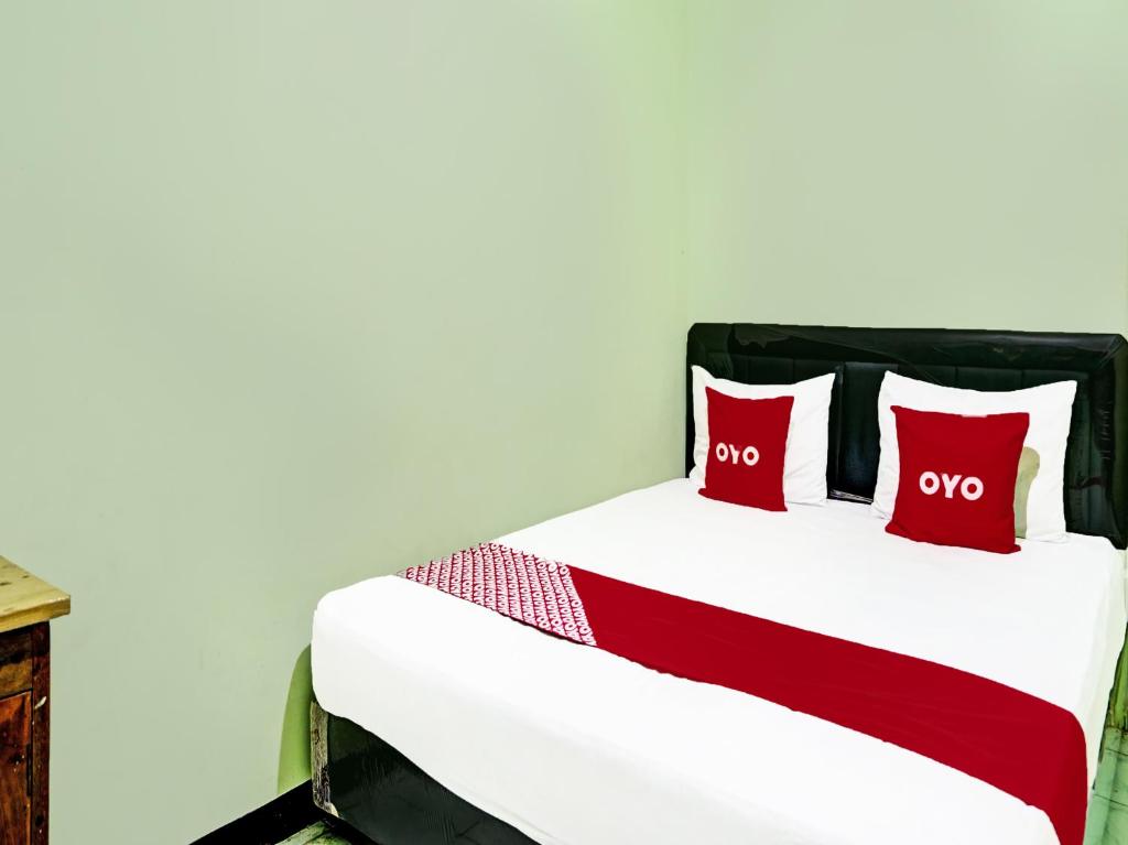 RamekasanOYO 2708 Hotel Kemuning Syariah的房间里的床上有两个红色枕头