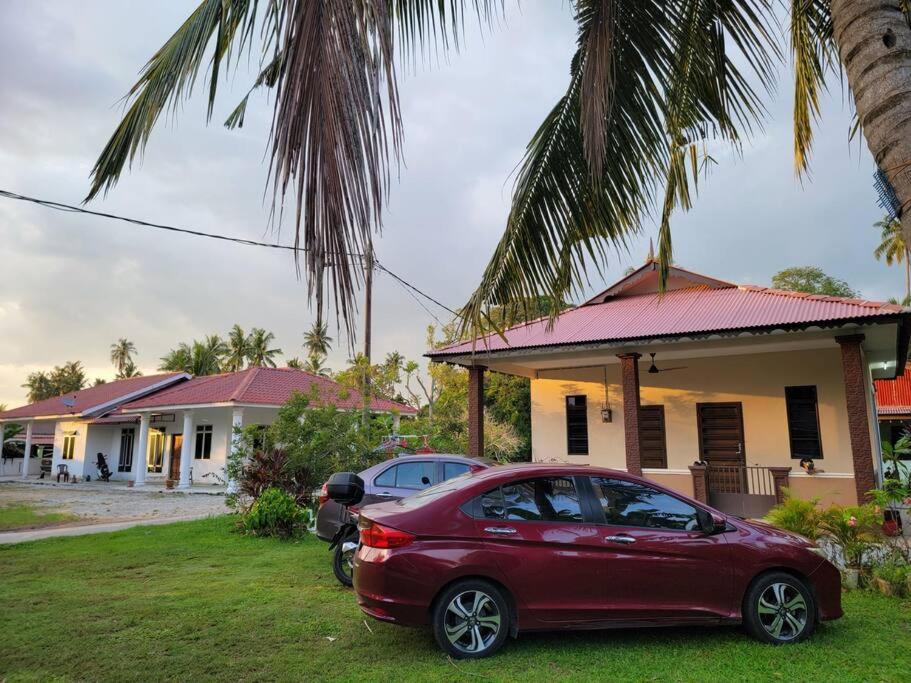 马六甲NusaTuah Roomstay的停在房子前面的红色汽车