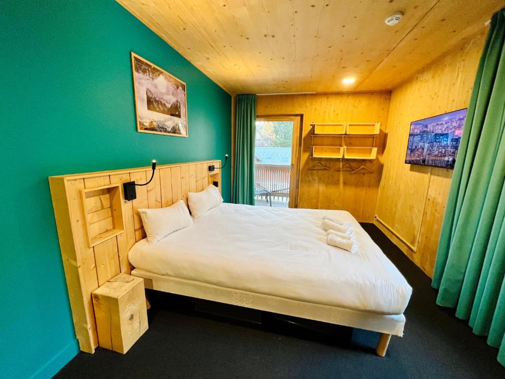 莱德萨阿尔卑斯The People - Les 2 Alpes的一间卧室设有一张床和绿色的墙壁