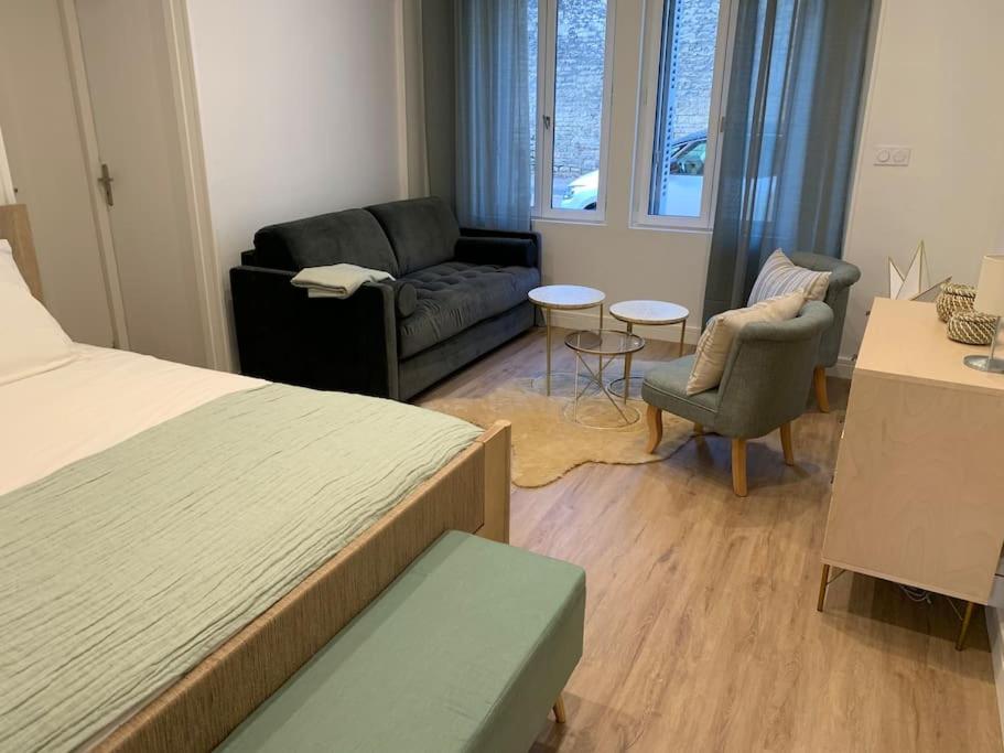 第戎Appartement chaleureux的一间卧室配有一张床、一张沙发和椅子