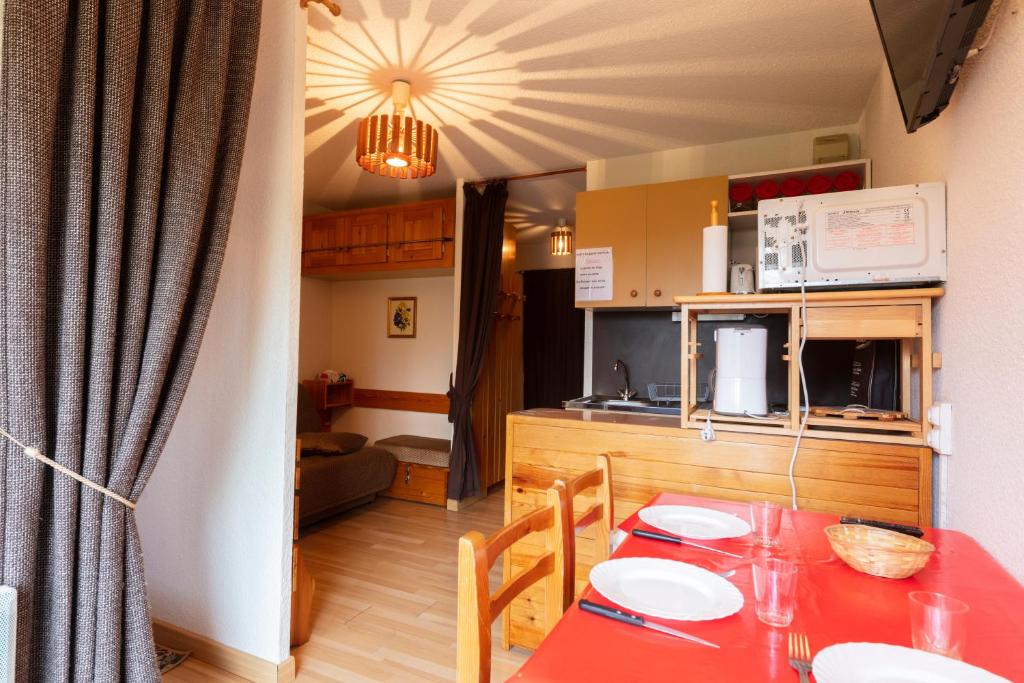 圣雷热雷梅累兹Equiria - 1 chambre - balcon的厨房以及带红色桌子的用餐室。