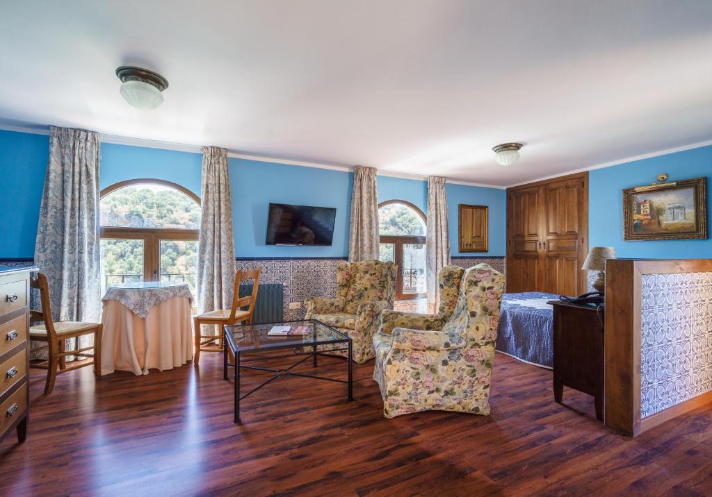 鲁伊德拉艾奥巴曼捷乡村酒店的蓝色的墙壁和一张床及椅子的房间