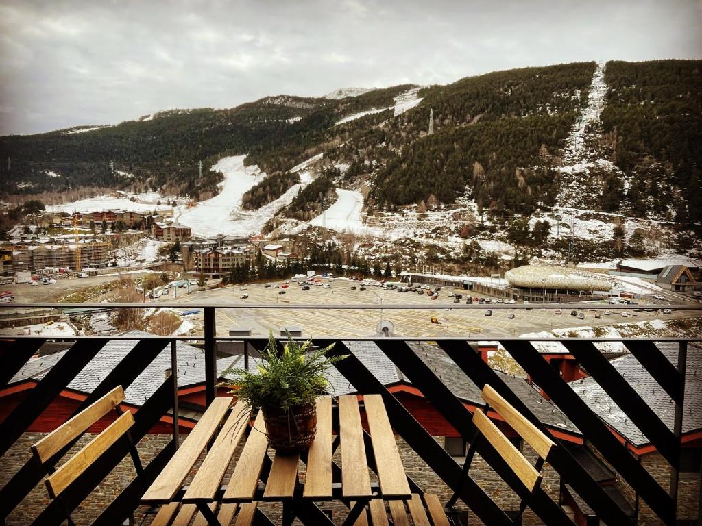埃尔塔特Apartament Mufló Apartamento encantador con vistas espectaculares a la X de Grandvalira的坐在滑雪场顶部的木凳