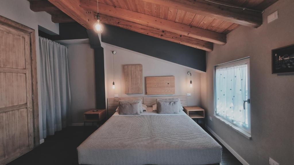 巴多利诺Bardoliners的一间卧室设有一张床和一个大窗户