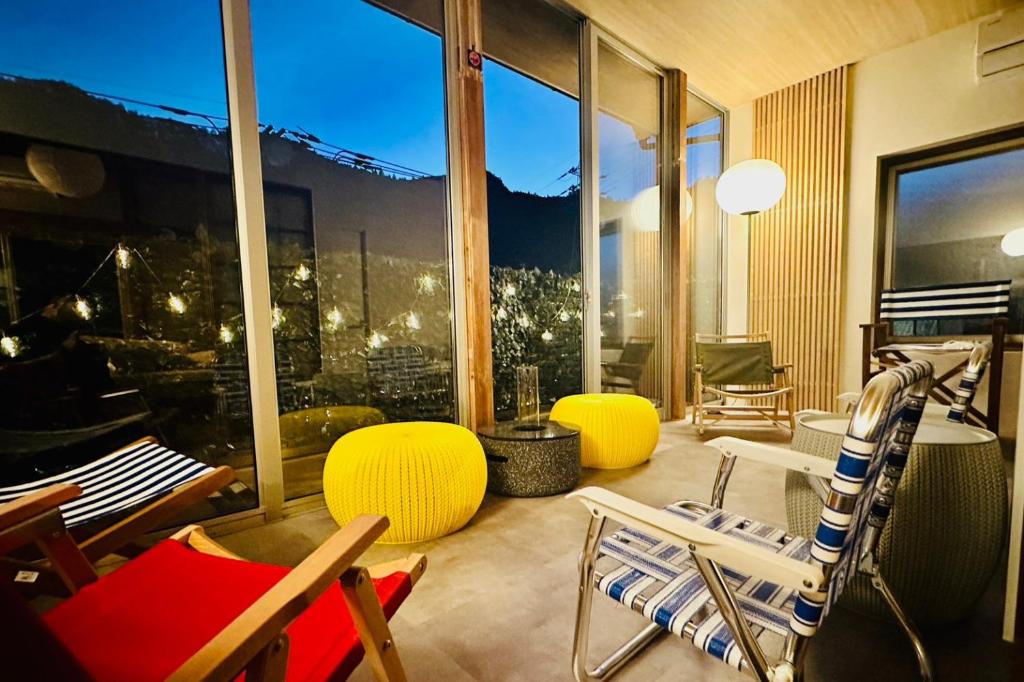 青梅市加美屋リゾート奥多摩 テラス＆風呂的客厅配有椅子和大窗户