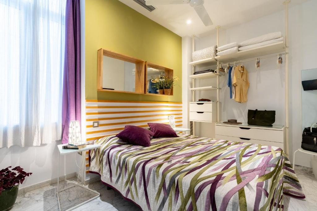塞维利亚塞维利亚普尔塔赫雷斯站中央套房公寓的一间卧室配有一张带紫色枕头的床