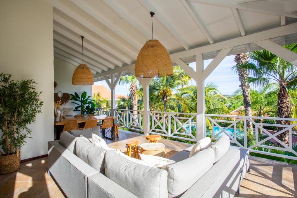 简蒂埃尔Tropicana Palm Penthouse Jan Thiel, Willemstad Curacao的户外客厅配有白色家具和棕榈树