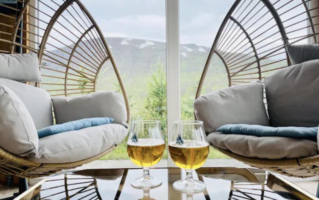 Hidden Cottages的两杯白葡萄酒坐在窗前的桌子上