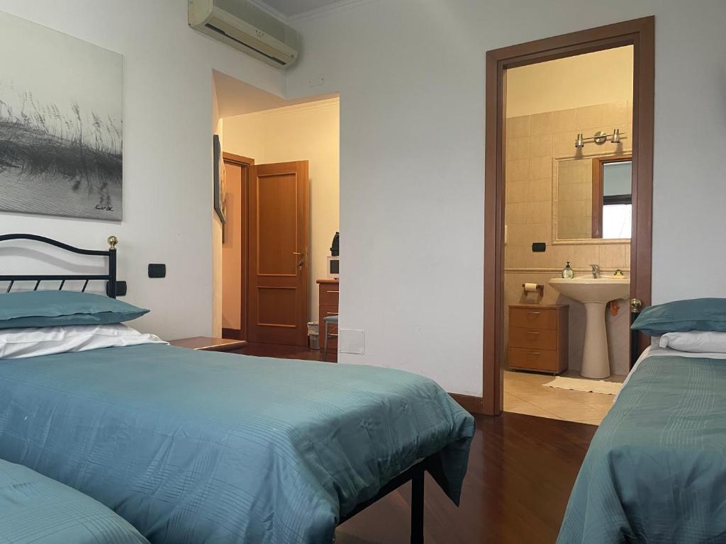 Portobb Nuova Fiera di Roma的一间带两张床的卧室和一间带水槽的浴室