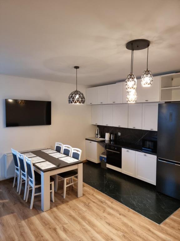 库特诺Apartament Oporowska 22A的厨房配有桌椅和黑冰箱。