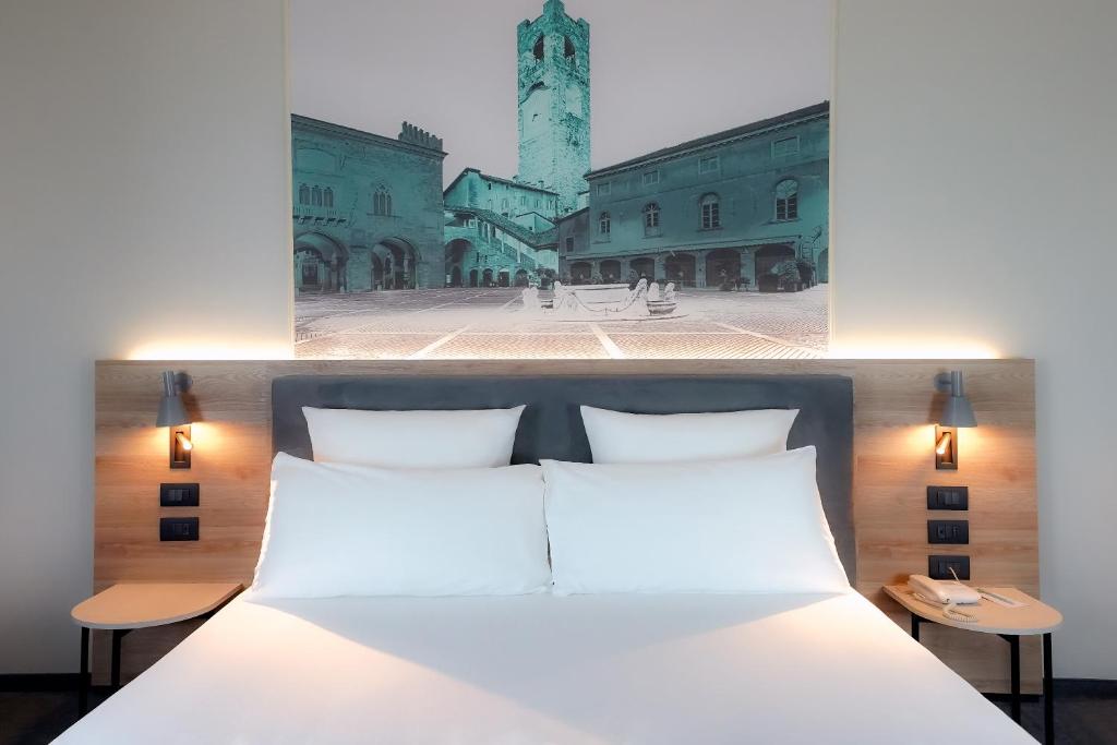 贝加莫贝加莫中心多尔斯宫美居酒店 的卧室配有白色的床和钟楼