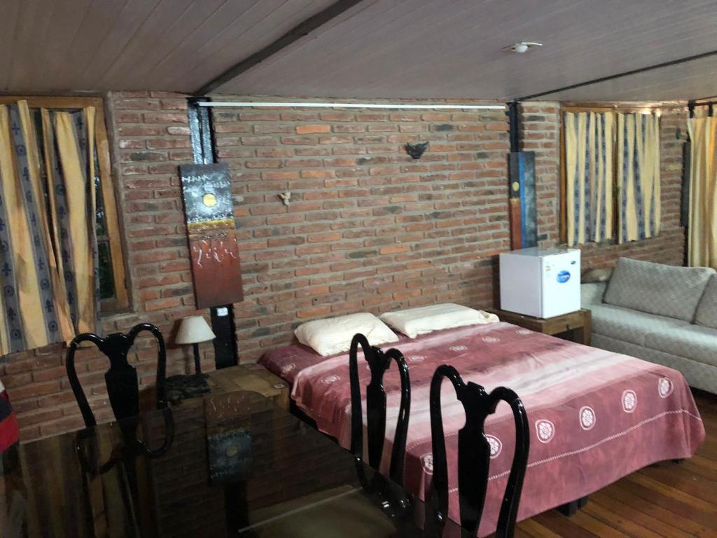 蒙得维的亚Loft casa dos pisos con garage pocitos playa 4 personas的一间卧室设有一张床和砖墙