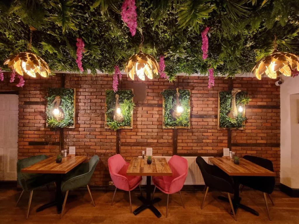蒙默思Creates的餐厅设有木桌和椅子,拥有砖墙