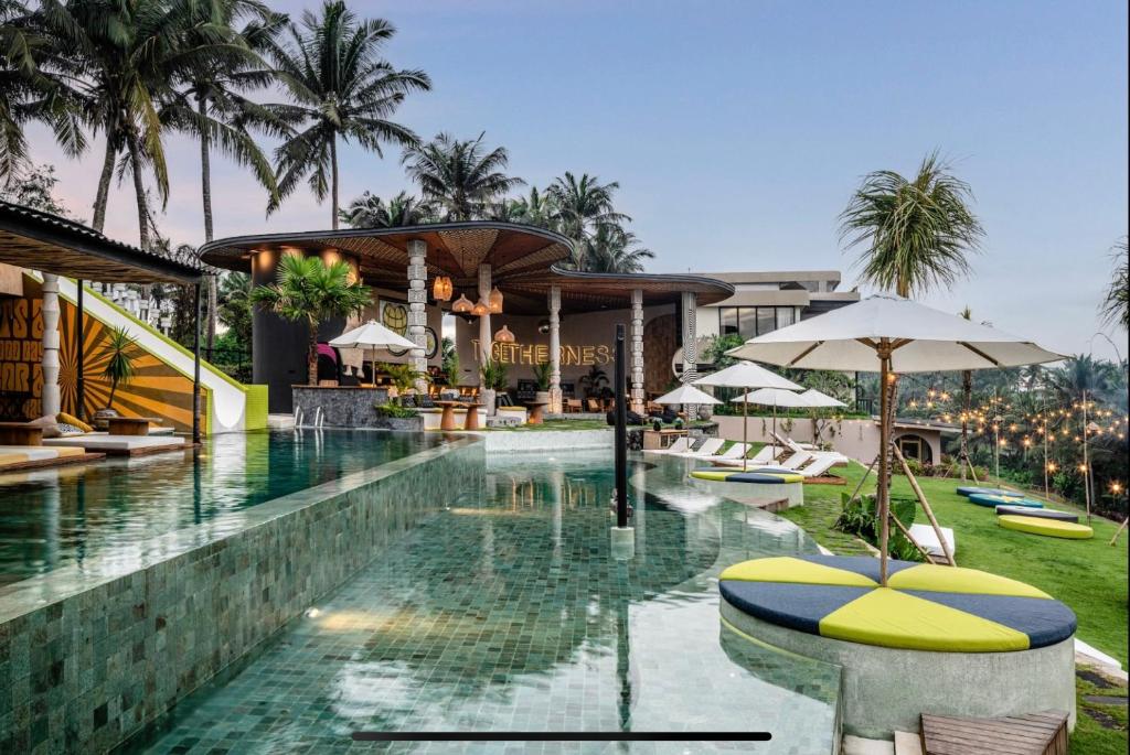 乌布巴厘索尔西旅馆的度假村的游泳池,配有椅子和遮阳伞