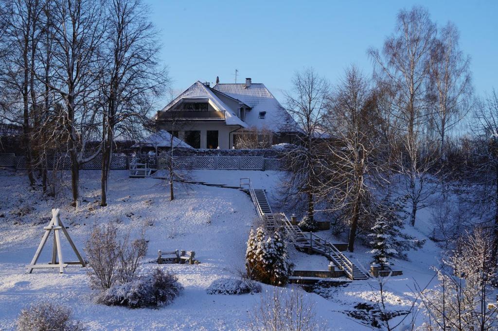 坎达瓦Jaunkrastmaļi的雪中的房子,前面有楼梯