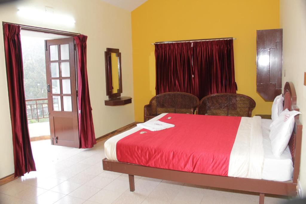 科代卡纳尔RPM Residency的一间卧室配有一张带红色床单的床和一扇窗户。