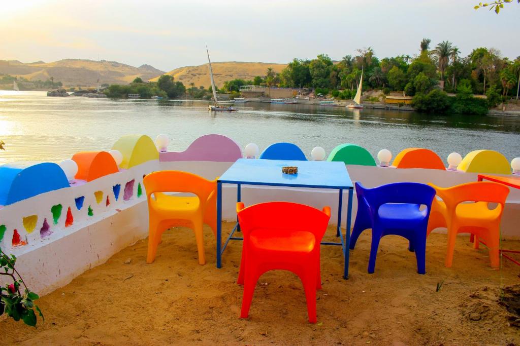 阿斯旺Hamo Guest House的一张桌子,旁边是五颜六色的椅子