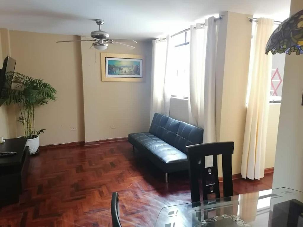 利马Departamentos Las Lilas Surco Lima的带沙发和玻璃桌的客厅
