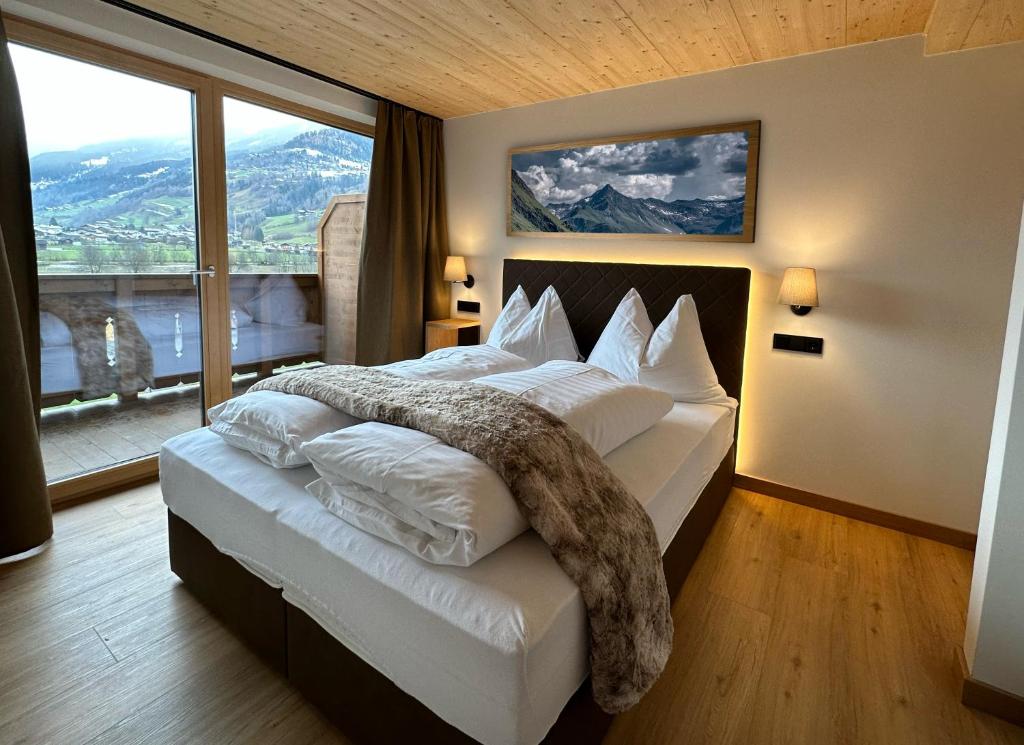 维尔德科格尔山麓布兰贝格Dorferwirt的一间卧室设有一张大床和大窗户