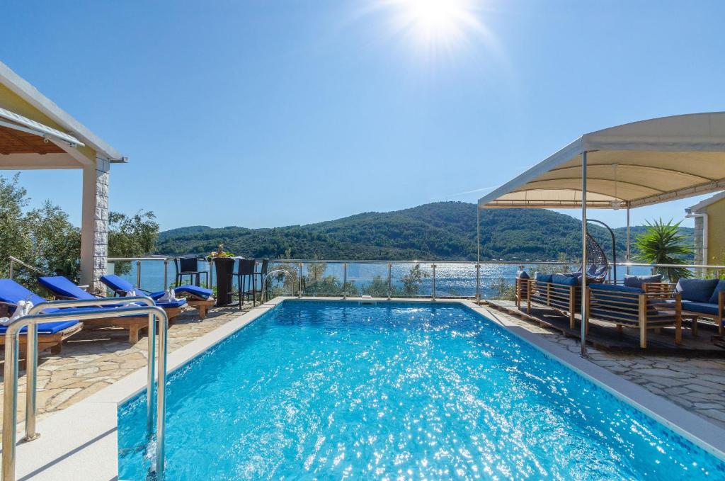 尼亚卢卡Villa Paradise的一个带椅子的游泳池,享有水景