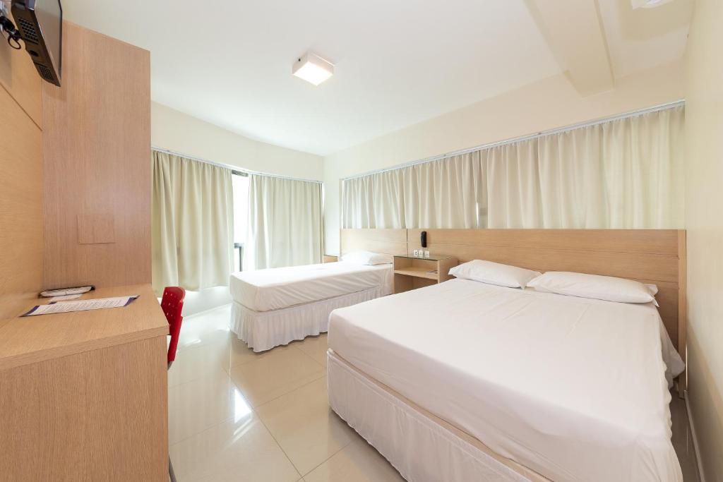 圣若泽Slim São José Zion的一间位于酒店客房内的带两张床的卧室