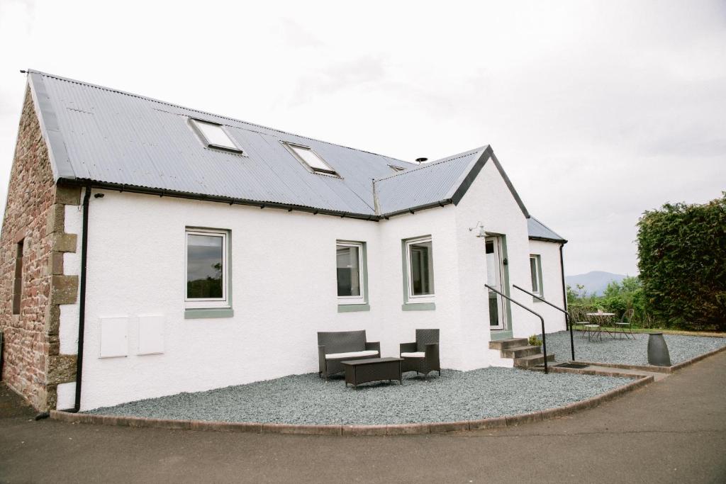 GartocharnDunruadh Cottage的石灰屋,带桌椅的白色房屋