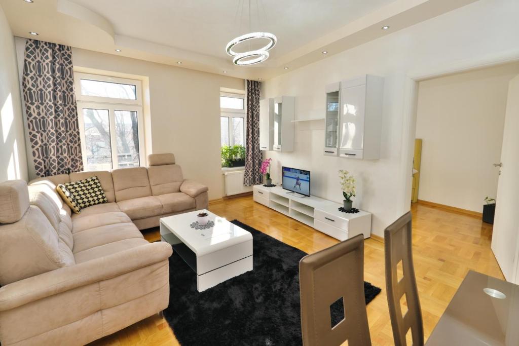 维也纳卢克斯尊贵公寓的客厅配有沙发和桌子