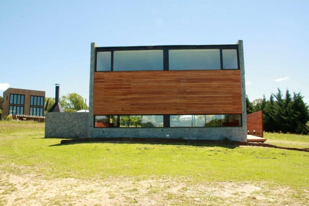本塔纳山村Hoyo 6 Rincón del Golf的草场上的房子,有楼房