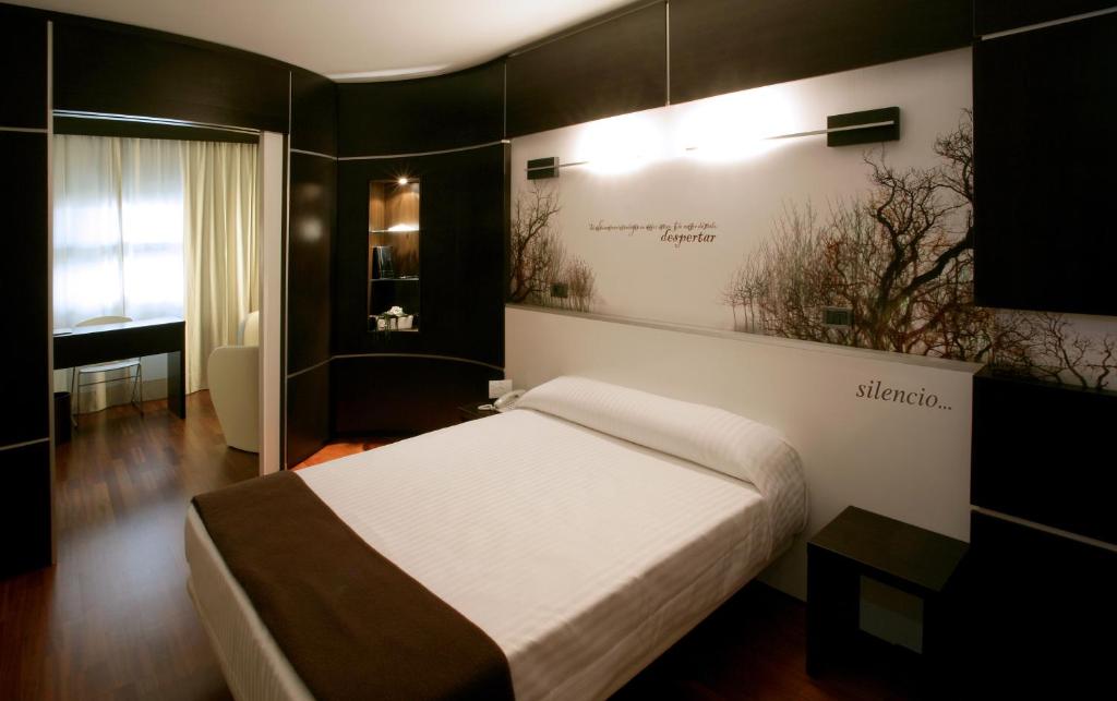 乌特沃欧罗巴酒店的卧室配有一张挂有墙上标志的床
