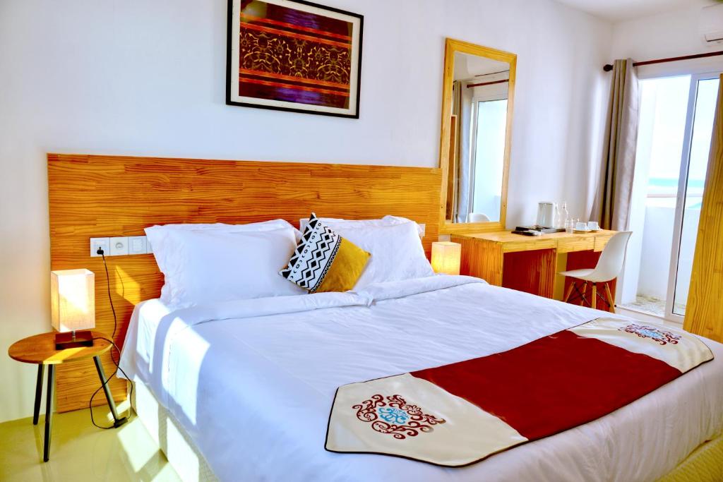 马富施Island Ambience的一间卧室配有一张大床,铺有红白毯子