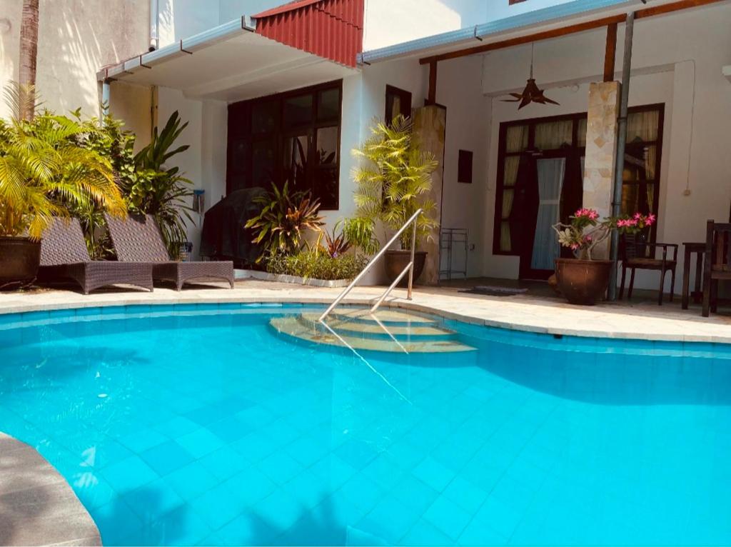 库塔Villa Cantik Kuta Regency的房屋前的游泳池