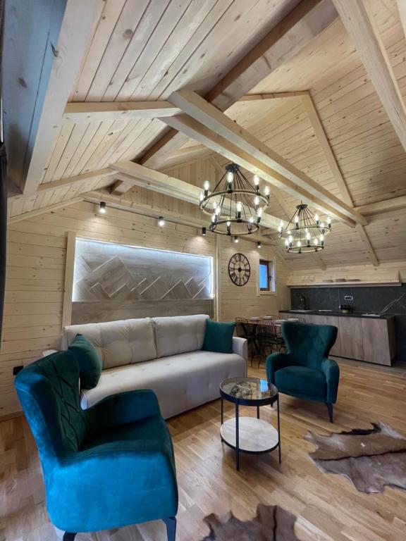 科拉欣Chalet Montenegrina with jacuzzi的客厅配有沙发、两把椅子和一张桌子