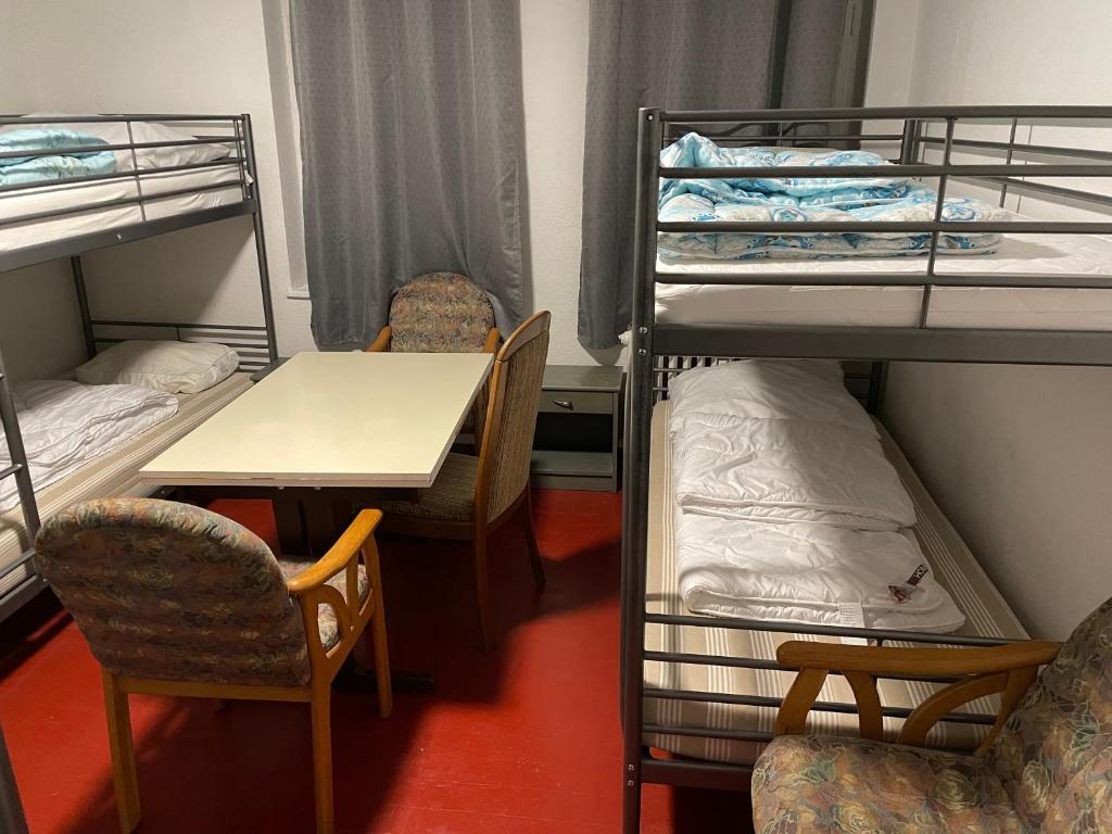 纽伦堡Hostel Sofia的客房设有双层床和桌椅。