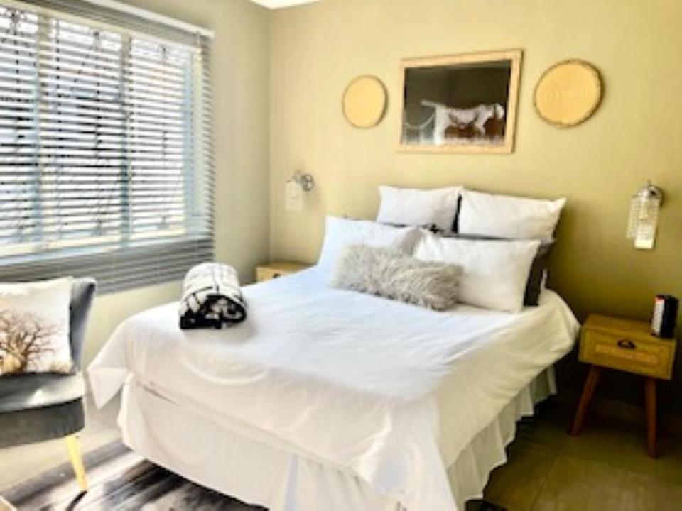 eMbalenhleEmba Guest lodge No loadshedding的窗户客房内的一张大白色床